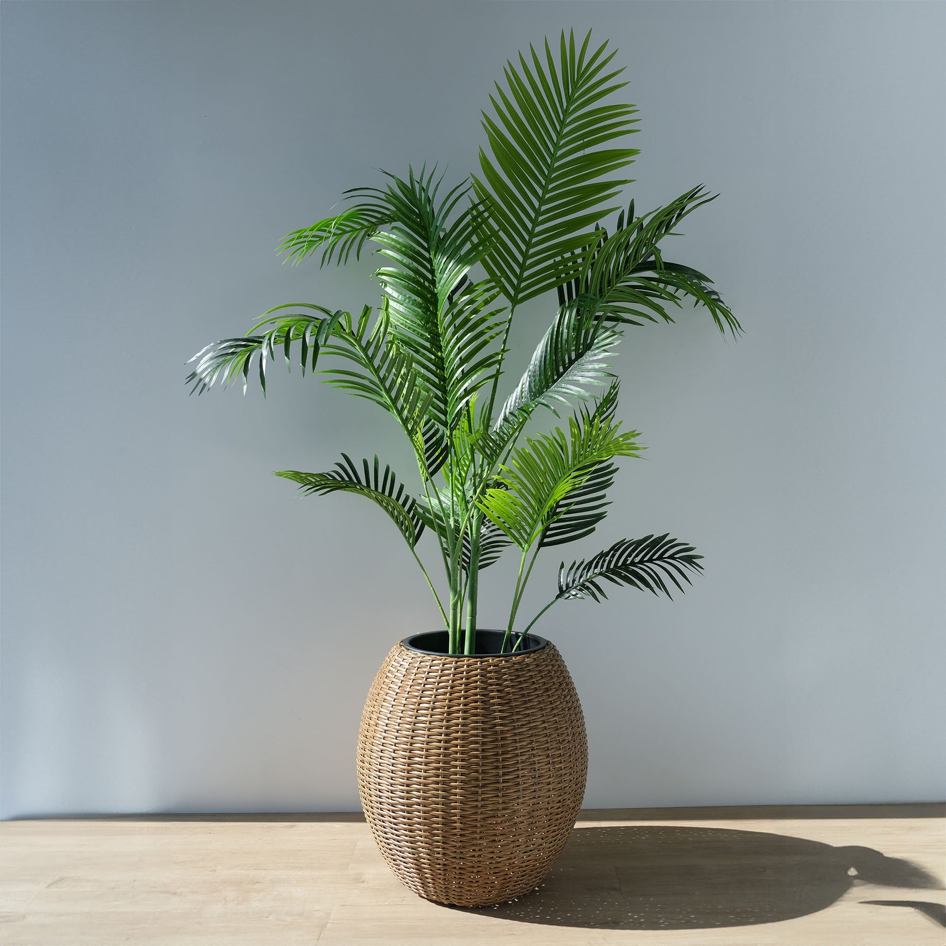 large light brown rattan planter with a faux-palm