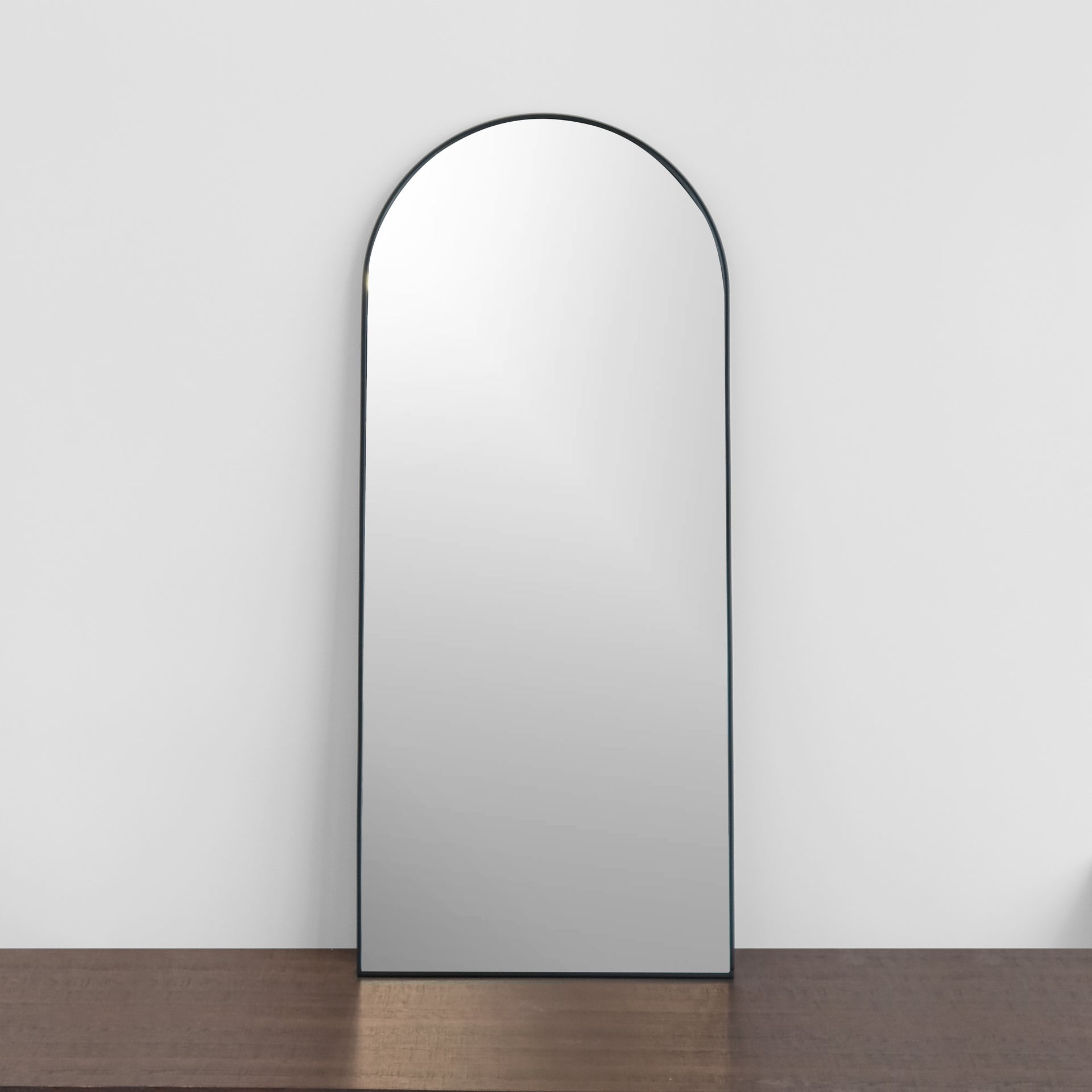 front view of 30x70 inch black arch mirror leaning