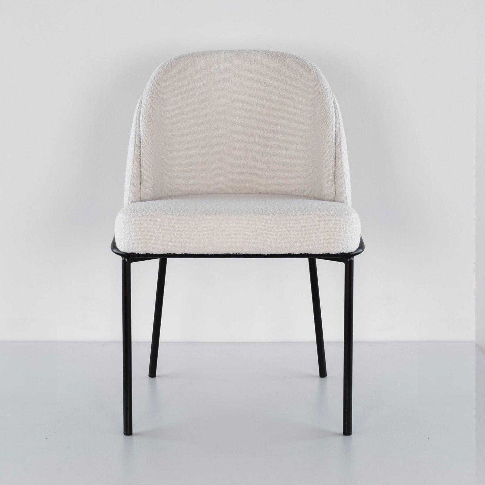 Front view of an off white boucle dining 