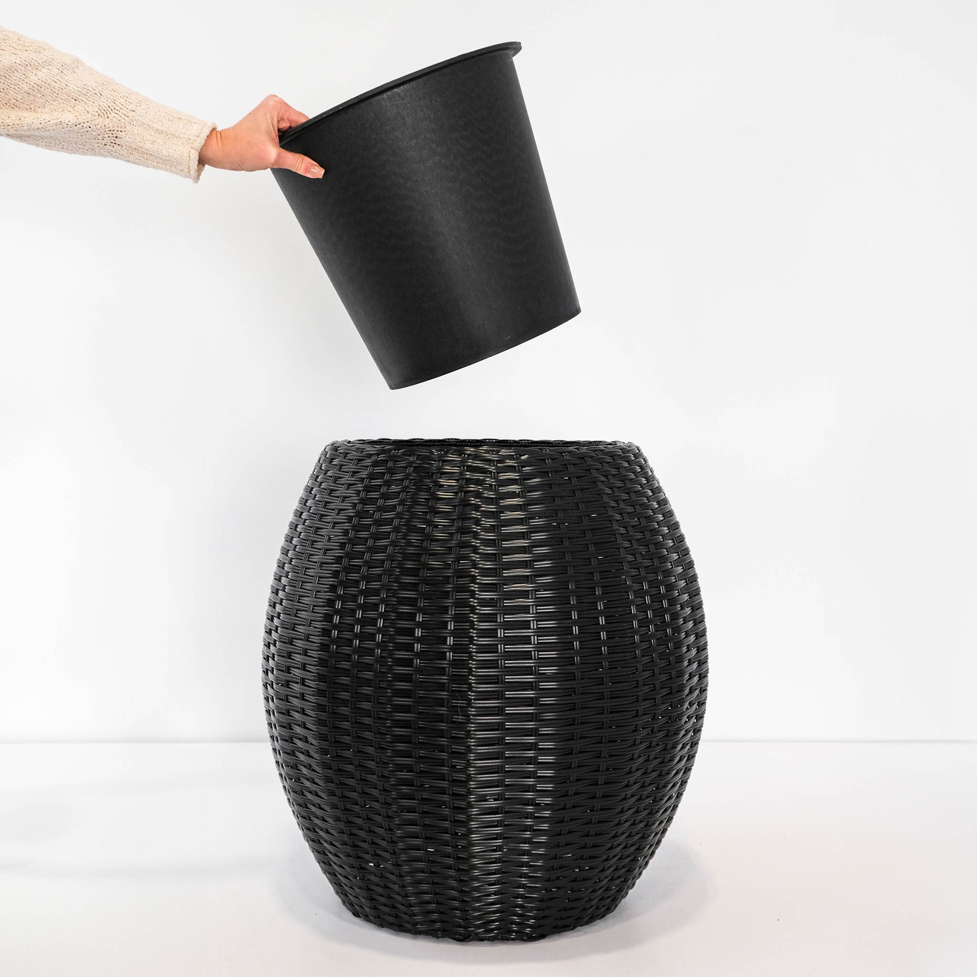 lack rattan planter with pot for elevated plant display.