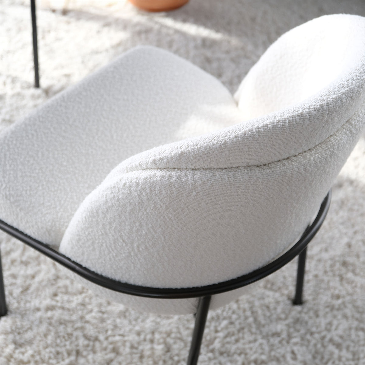 Top view of a modern boucle dining chair, highlighting its stylish design and textured upholstery.