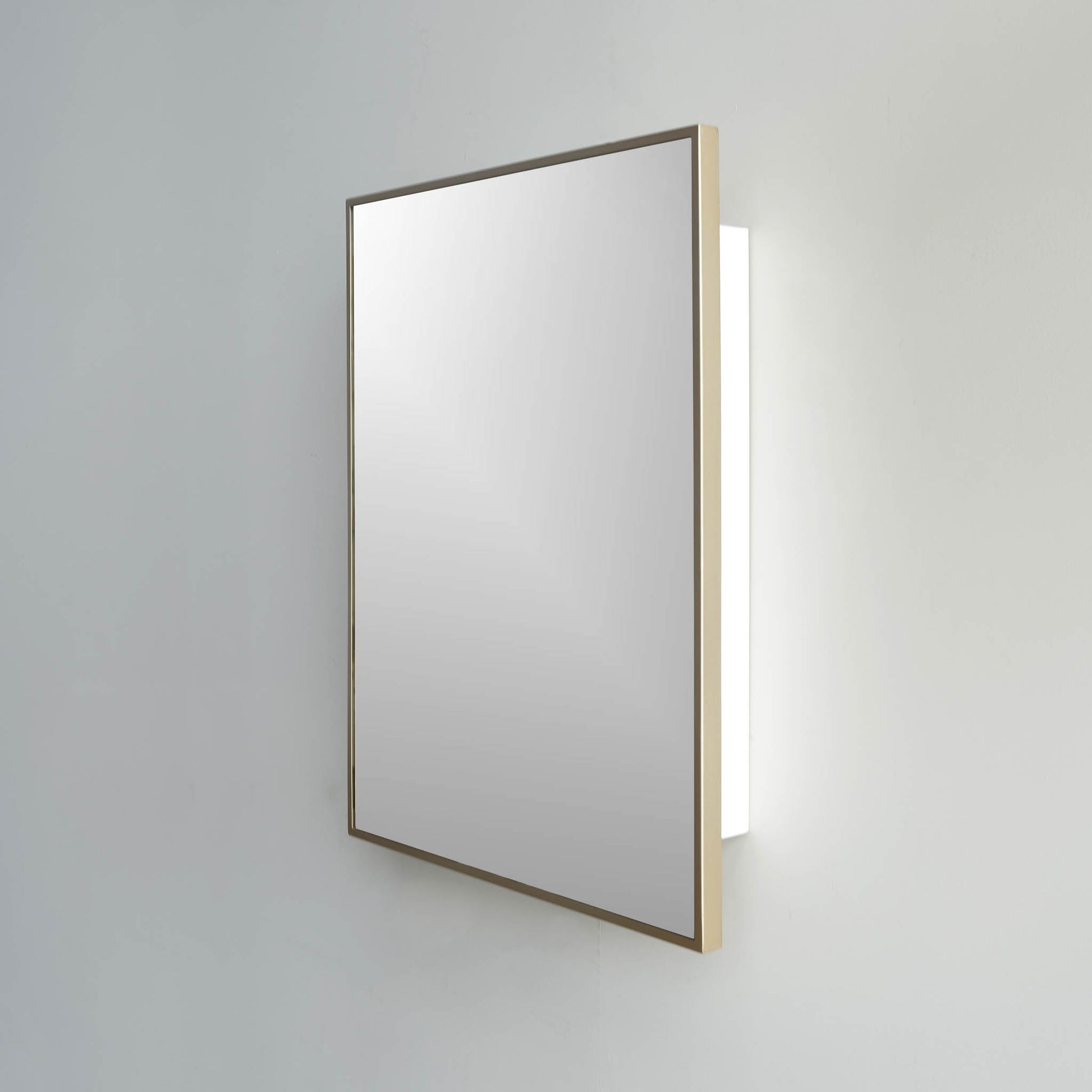 Modern rectangle with square edges gold medicine cabinet against a white wall.