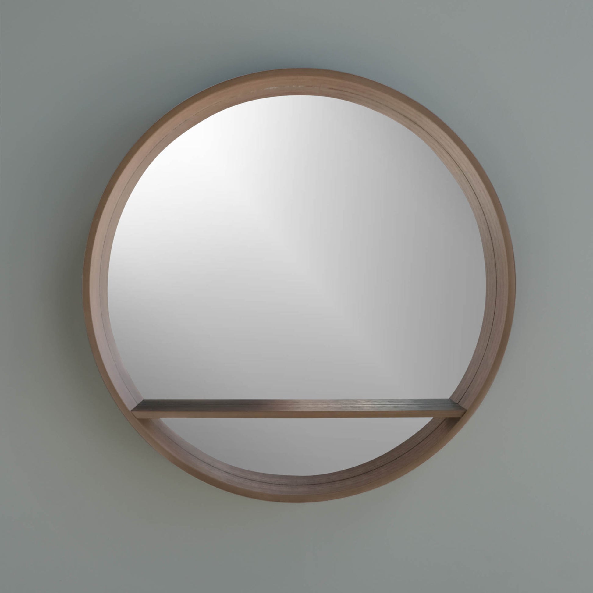 pear round mirror with a shelf, thick frame hanging on a wall