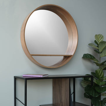 round pear mirror with a shelf and a faux-plant
